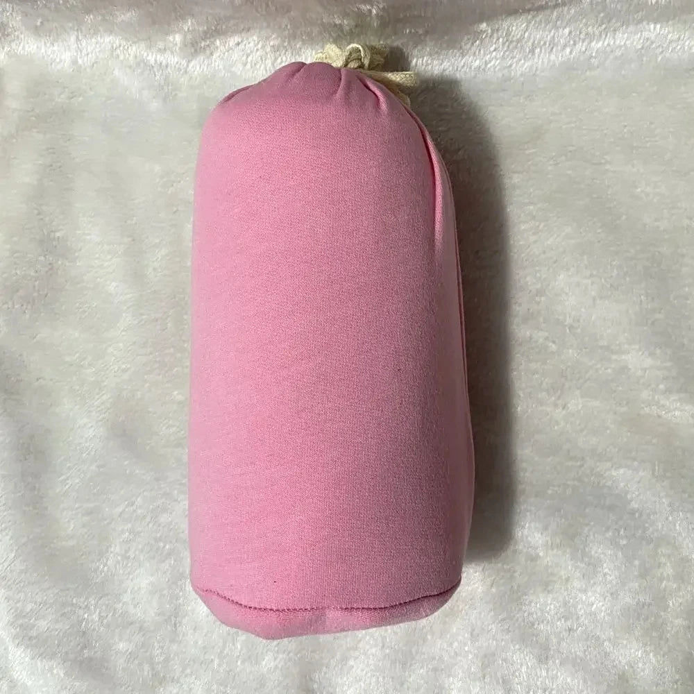 A baby sling wrap carrier with a sleeping infant inside, worn by an adult with one hand supporting the baby's head.