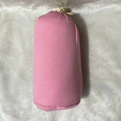 A baby sling wrap carrier with a sleeping infant inside, worn by an adult with one hand supporting the baby's head.