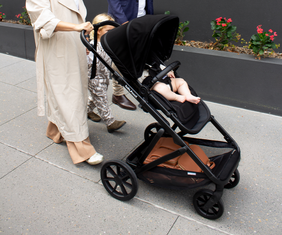 Far lifestyle image of Babyhood Doppio Plus stroller with bassinet, perfect for infants on a smooth walk.”