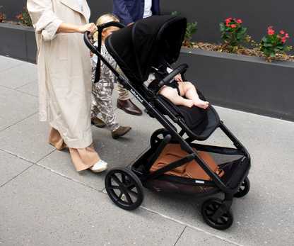 Far lifestyle image of Babyhood Doppio Plus stroller with bassinet, perfect for infants on a smooth walk.”