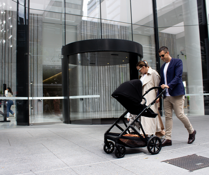 Lifestyle image of Babyhood Doppio Plus stroller with bassinet, perfect for infants on a smooth walk.