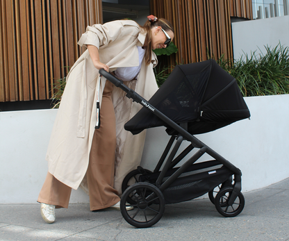 Lifestyle image of Babyhood Doppio Plus stroller with bassinet, perfect for infants on a smooth walk.