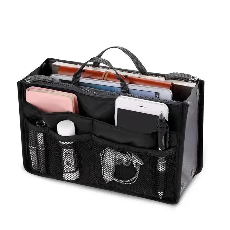 A black compact bag organiser insert with various compartments, some containing cosmetics or electronic devices, displayed against a white background.