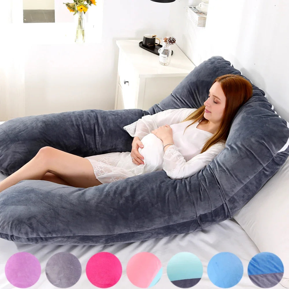 A pregnant woman lying on a gray pregnancy bump support pillow with a solid pattern.