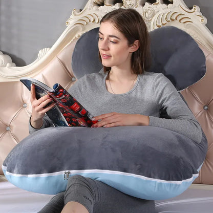 A pregnant woman lying on a gray pregnancy bump support pillow with a solid pattern.