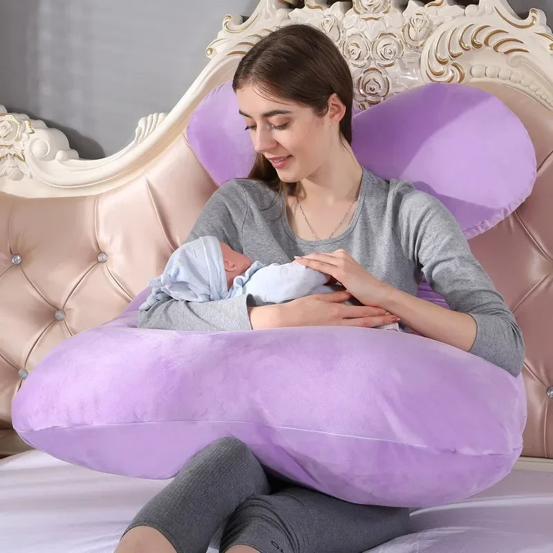 A pregnant woman lying on a purple pregnancy bump support pillow with a solid pattern.