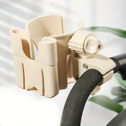 A beige stroller cup and phone holder attached to the handle of a black stroller.